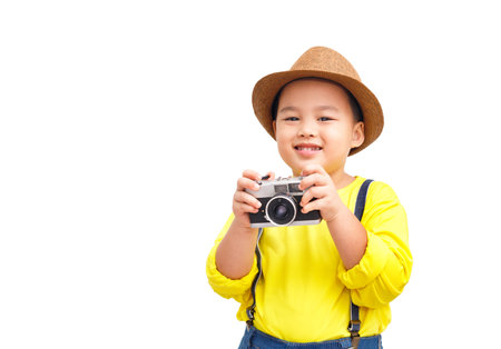 Cute boy having fun with his vintage camera and going on a trip as a tourist.の写真素材