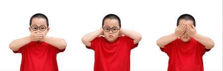The little boy in red t-shirt shows symbols of the tree wise monkeys. three wise businessman that they did not hear, speak and see. See no evil, hear no evil, speak no evil. Religion Buddhism.の写真素材