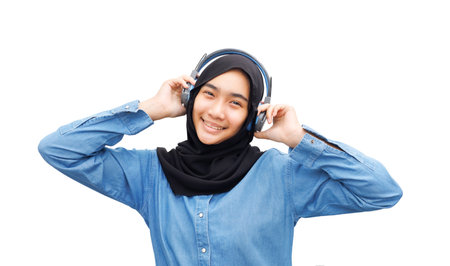 A Muslim girl listened to music with headphones.の写真素材