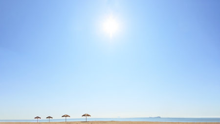Calm sea beach and thatched roof umbrella.の写真素材