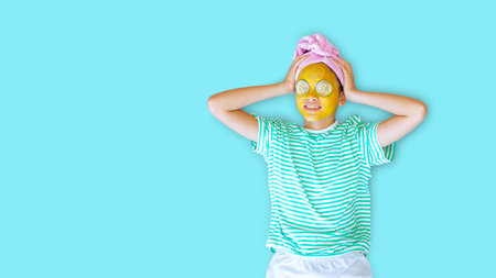 Young asian woman with cucumber and turmeric cream mask on her face.の写真素材