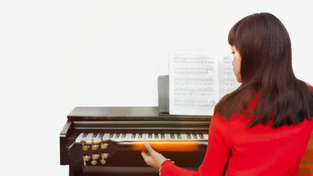 The girl composes songs with a guitar and piano.の写真素材
