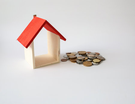 Mini house and coins isolated on a white background. Concept of Investment propertyの写真素材