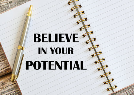 Top view of a pen with Believe In Your Potential written on a notebook.の写真素材
