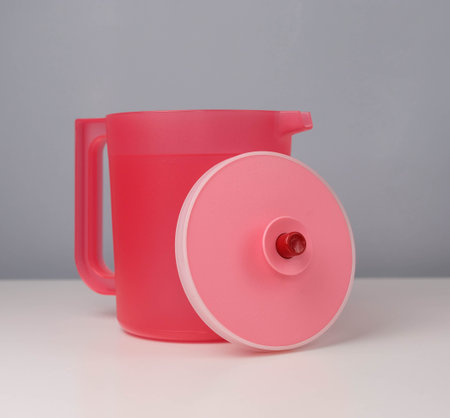 Red jug isolated on a grey and white background.の写真素材