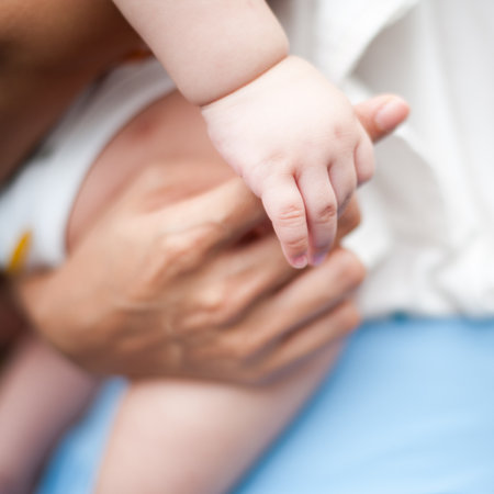 Baby hand gently holding adultの写真素材