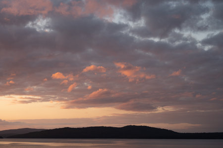 Sunset over the lake. Beautiful sunset on the lake. Sky with clouds.の写真素材