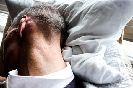 The back of a sleeping man besides the windowの写真素材