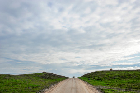 A road that seems to end  behind the hillの写真素材