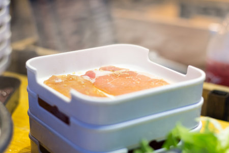 Fresh meat is placed in a food tray.