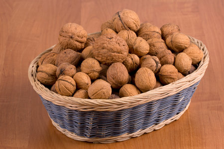 Nuts in a basket on a wooden backgroundの写真素材