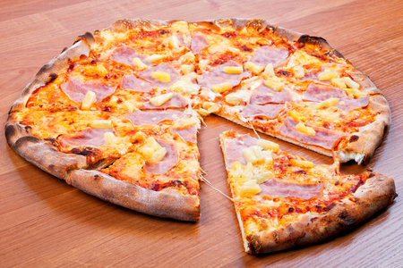 Hawaiian pizza on a wooden backgroundの写真素材