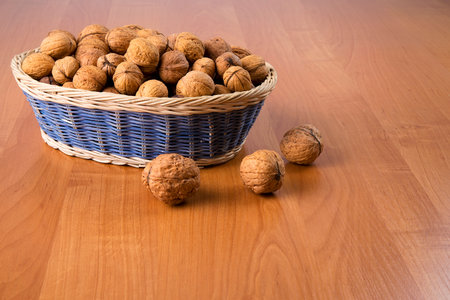 Nuts in a basket on a wooden backgroundの写真素材