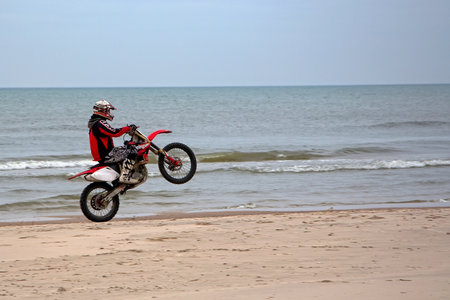 Motorbiking on one wheel at the seasideのeditorial素材