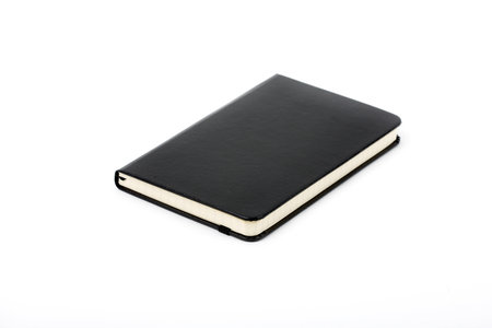 Black closed notebook on a white backgroundの写真素材
