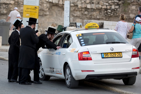 Jerusalem, Israel - May 1: Orthodox Jews order a taxi on the street`s of Jerusalem on May 1, 2018 in...