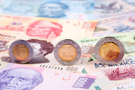 Mexican Peso coins on the background of banknotesの写真素材