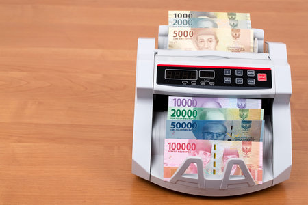 Indonesian rupiah in a counting machineの写真素材