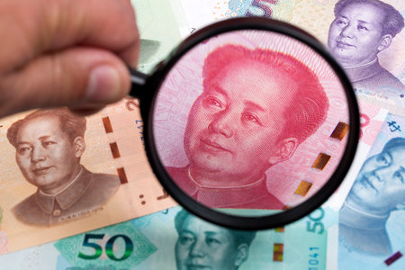 Chinese Yuans in a magnifying glass a business background