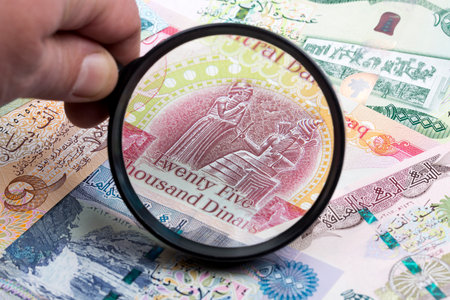 Iraqi dinar in a magnifying glassの写真素材
