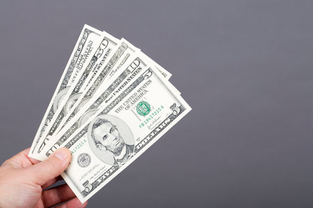 Old money from USA - dollars in the hand on a gray background