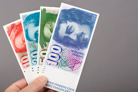 Old Swiss money - franc in the hand on a gray backgroundの写真素材