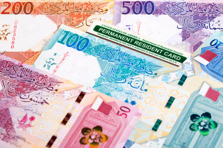 American permanent resident card on Qatari money - riyalの写真素材