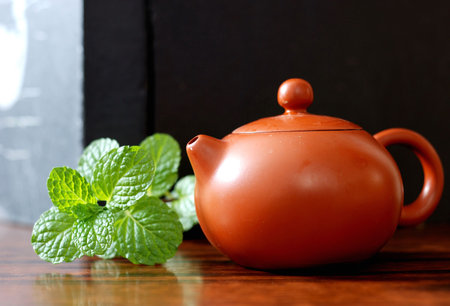 Asian teapot with sprigs of mint for teaの写真素材