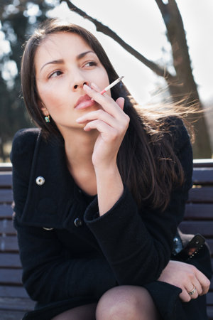 Young woman smokes on the streetの写真素材