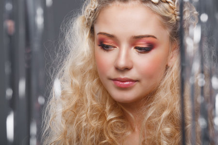Beautiful blonde looks through the curtains of silverの写真素材