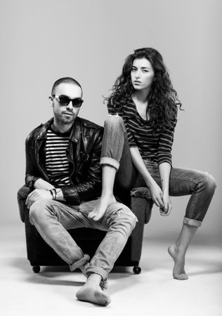 A beautiful young couple sitting in a chairの写真素材