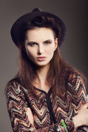Woman with open lips in hat on dark background, indoorの写真素材