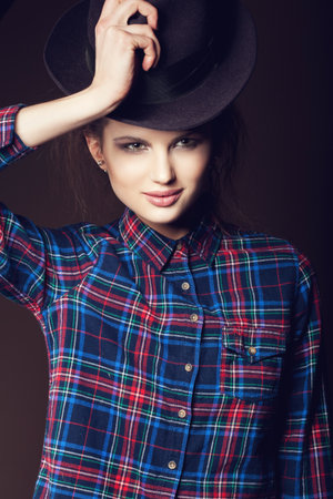 Woman with open lips in hat on dark background, indoorの写真素材