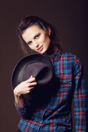 Woman with open lips in hat on dark background, indoorの写真素材