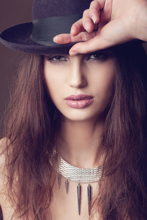 Woman with open lips in hat on dark background, indoorの写真素材