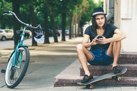 Happy skateboarder sitting on stairsの写真素材