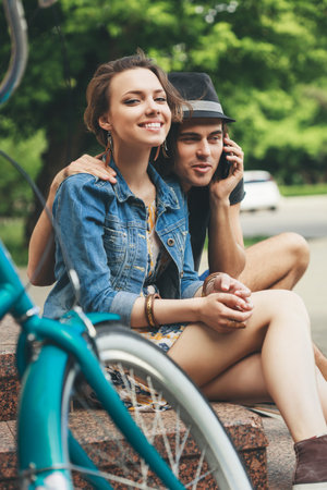 Happy girl and boy relaxing sitting on the stairsの写真素材
