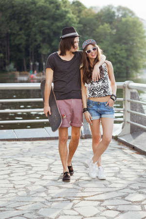 Happy couple walking on the bank of a riverの写真素材