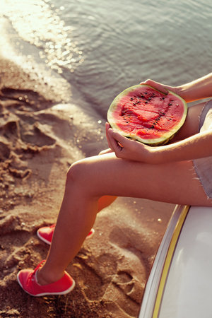 Portrait of a beautiful woman with watermelon on the beach. Lifestyleの写真素材