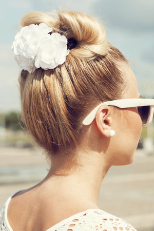 Beautiful girl with bow coiffure. Back view. Outdoors.