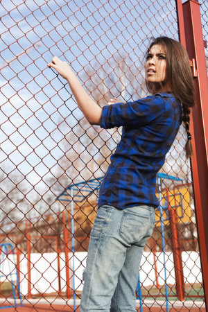 Portrait of a beautiful girl hipster. Trendy young naughty woman holding at the net. Outdoors, lifestyle.の写真素材