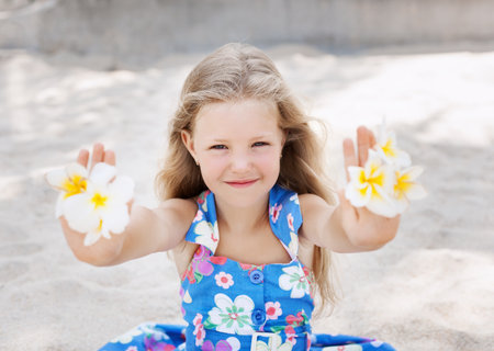 Beautiful young girl relaxing near the sea and holding flowers. Outdoorsの写真素材