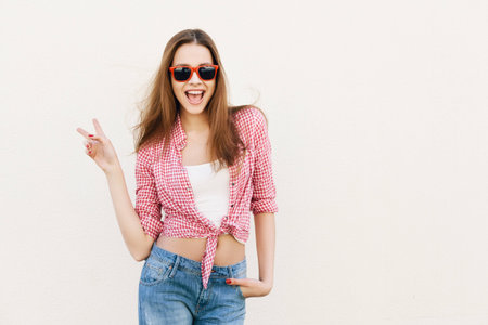 Young woman posing by the wall. Girl showing gesture. Not isolatedの写真素材