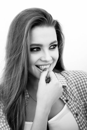 Closeup portrait of young woman smiling. Girl flirting. Black and white. Not isolated
