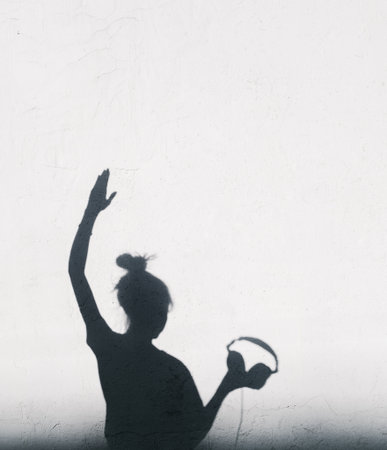 Woman with headphones lifting her hand up.の写真素材