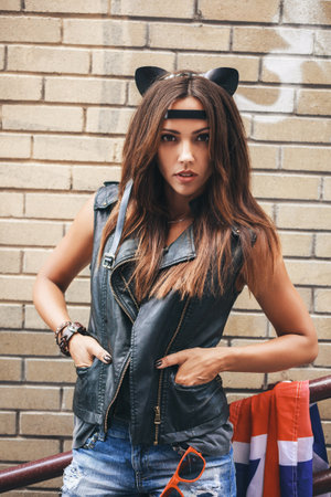 Bad sexy woman with leather cat ears. Urban scene. Outdoor lifestyle portraitの写真素材