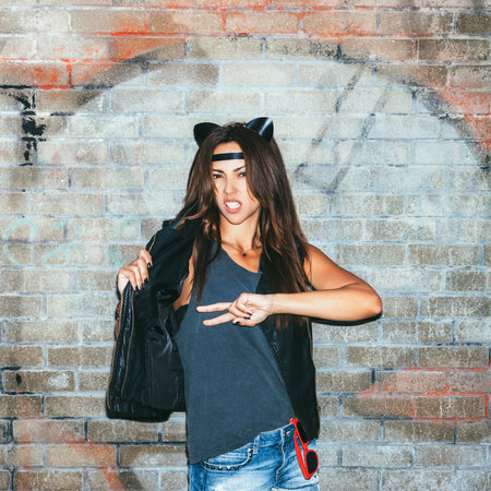 Bad girl  with leather cat ears. Urban scene. Outdoor lifestyle portraitの写真素材
