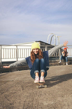 Two young  girl friends having fun. Downhill, longboarding . Outdoors, lifestyle.の写真素材