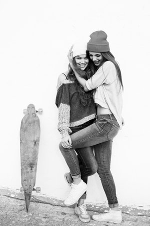 Two young hipster girl friends together having fun. Outdoors, lifestyle.の写真素材