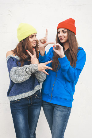 Two young hipster girl friends together having fun. Outdoors, lifestyle.の写真素材